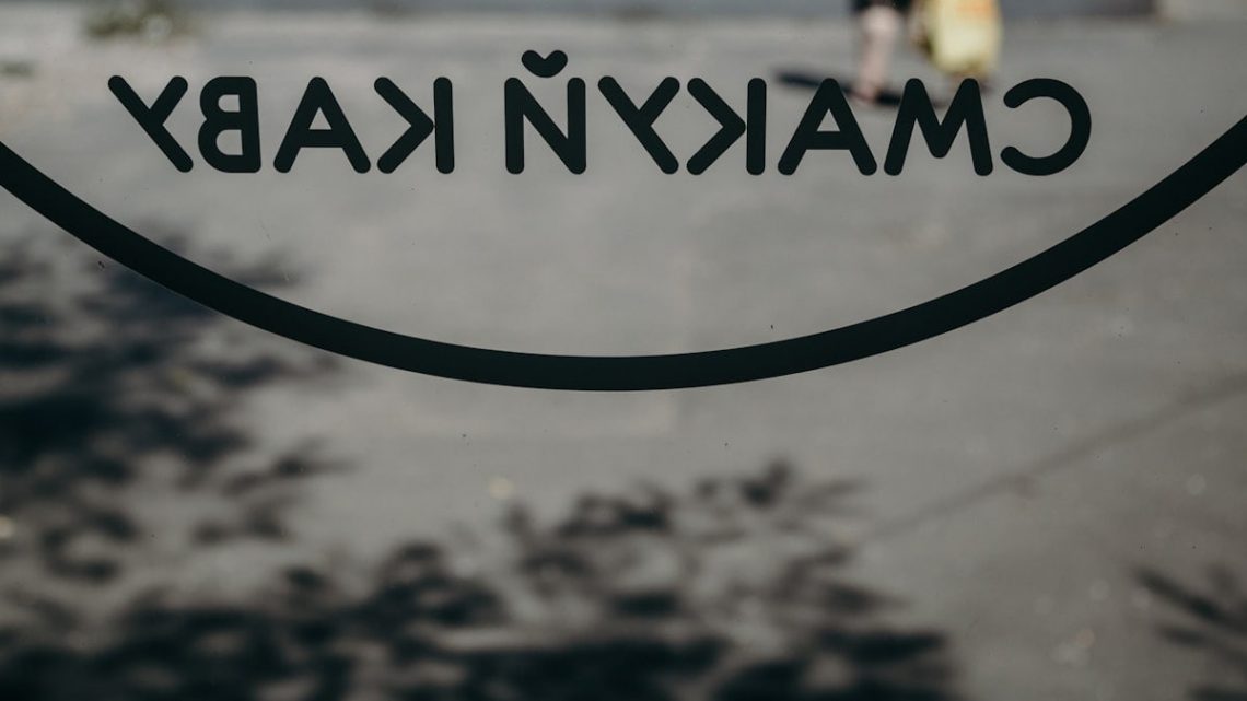 a close up of a sign with a person walking in the background