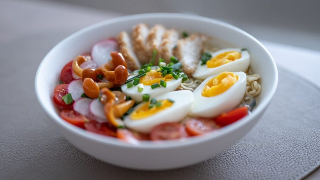 Bowl of noodles with chicken, eggs, and vegetables
