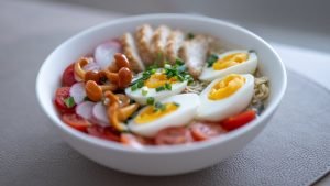 Bowl of noodles with chicken, eggs, and vegetables